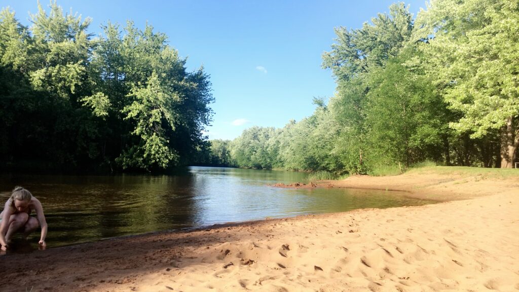 Person collecting shells on a sandy beach near the St. Croix National Scenic Riverway 